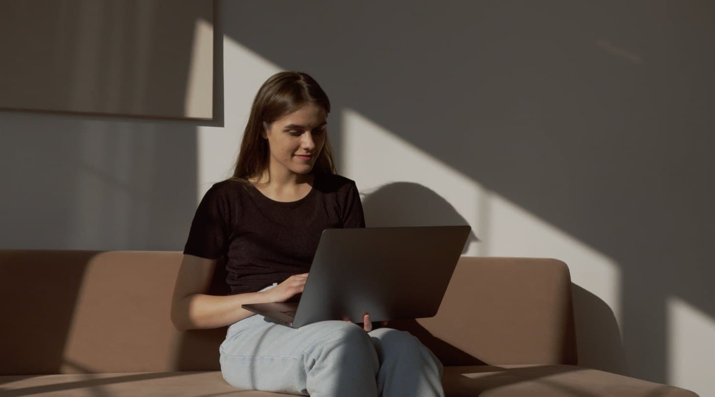 A woman on a sofa with her laptop on a quiet afternoon